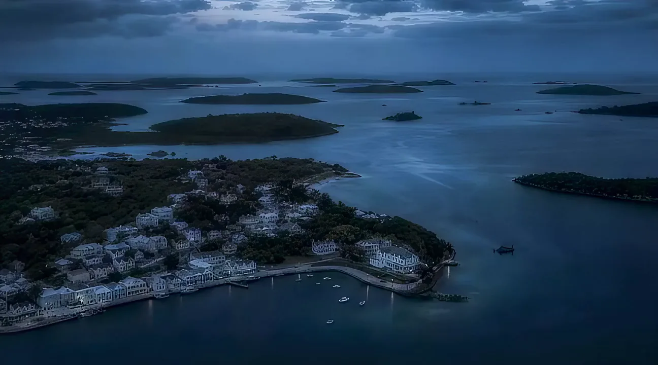 A broad calm channel of water running between wooded islands under heavy cloud.
